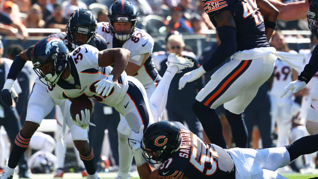 Jack Sanford hangs on for a tackle against Denver last season.